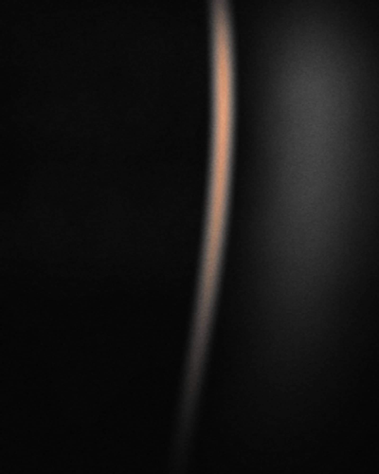Placeholder portrait — a rim of light describing an edge against a deep black ground.