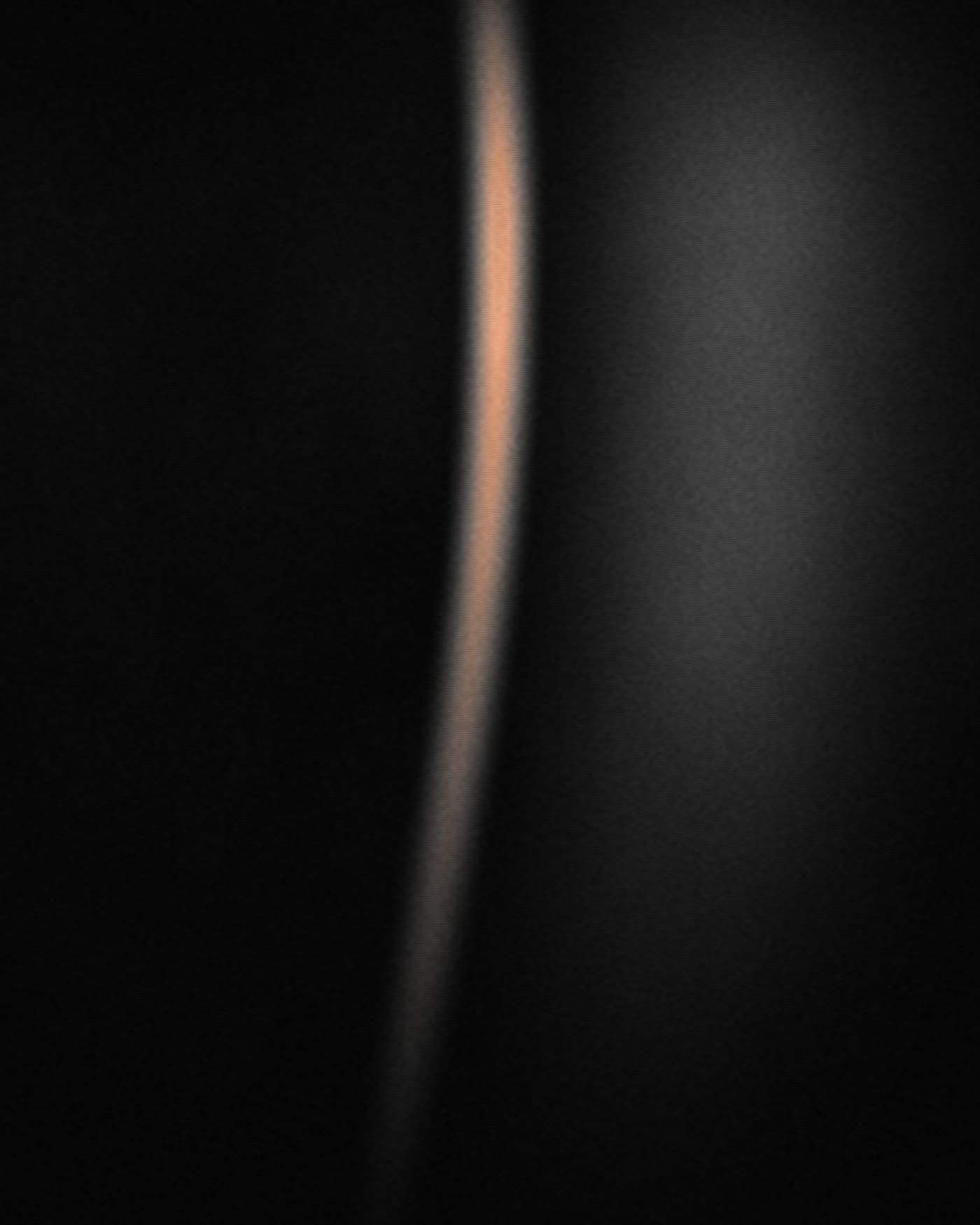 Placeholder photograph — a rim of light along an edge in the dark.